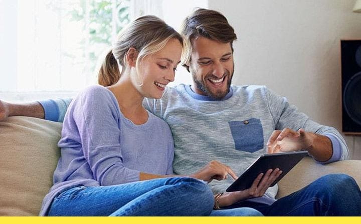 Двойка, коятo чете заедно книга на дивана